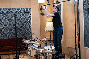 Miko Moon sets up overhead microphones in a recording studio