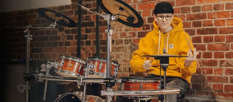 Miko Moon playing an electronic drum kit.