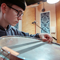 Miko Moon adjusts snare wires in the studio.