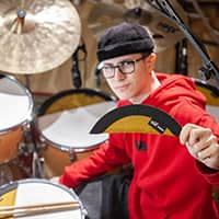 Miko Moon shows a damper next to the drum kit.