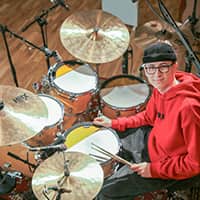 Miko Moon next to a miked drum kit.