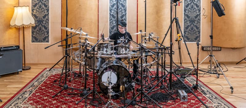 Miko Moon behind the drums in a recording studio.