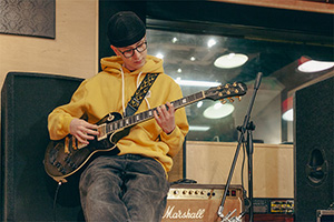Miko Moon plays guitar in the studio.